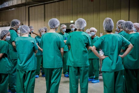 14 heures, c’est l’heure du briefing par le responsable médical du Centre de soins avancés de Luxexpo The Box. Face à des volontaires, il faut s’assurer que tout le monde a bien les consignes en tête. La guerre contre le virus se gagne là. (Photo: Romain Gamba)