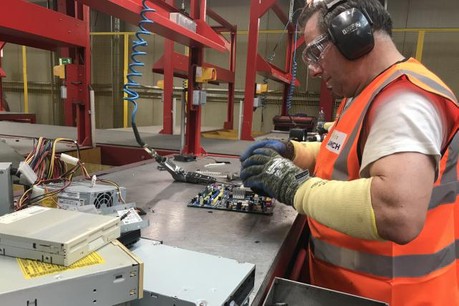 Un salarié de l’entreprise Lamesch est en train de désosser pièce par pièce une carte mère d’ordinateur. (Photo: Ioanna Schimizzi)